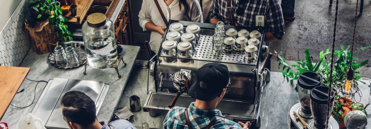 Patrons at a coffee shop discussing the CEBA loan repayment deadline extension