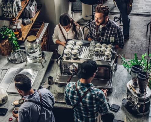 Patrons at a coffee shop discussing the CEBA loan repayment deadline extension