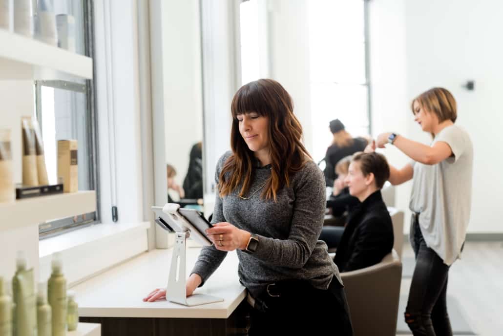 Hairdresser discussing CEBA Loan extension at a hair salon